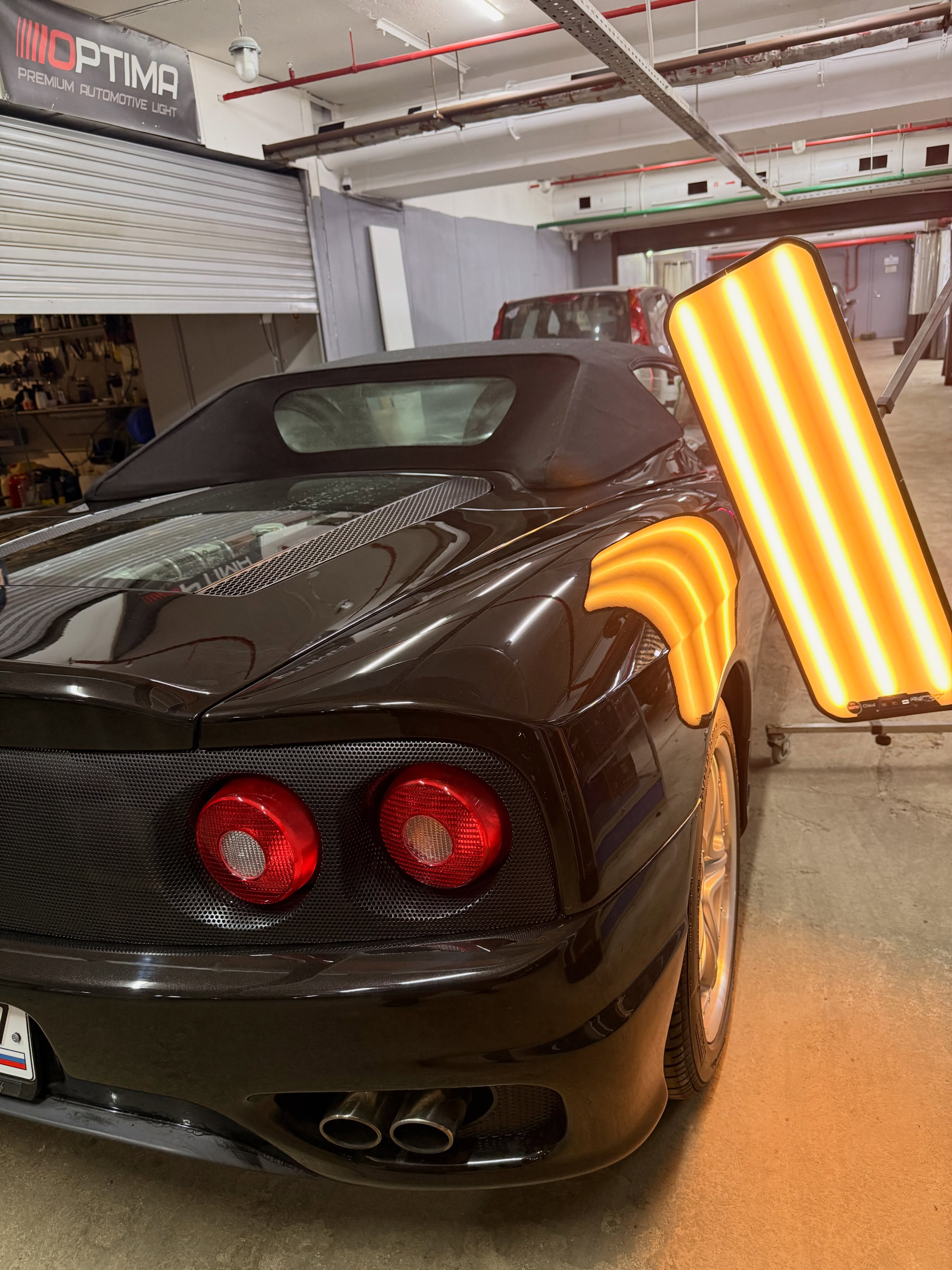 Чёрный кузов Ferrari под инспекционной PDR-лампой