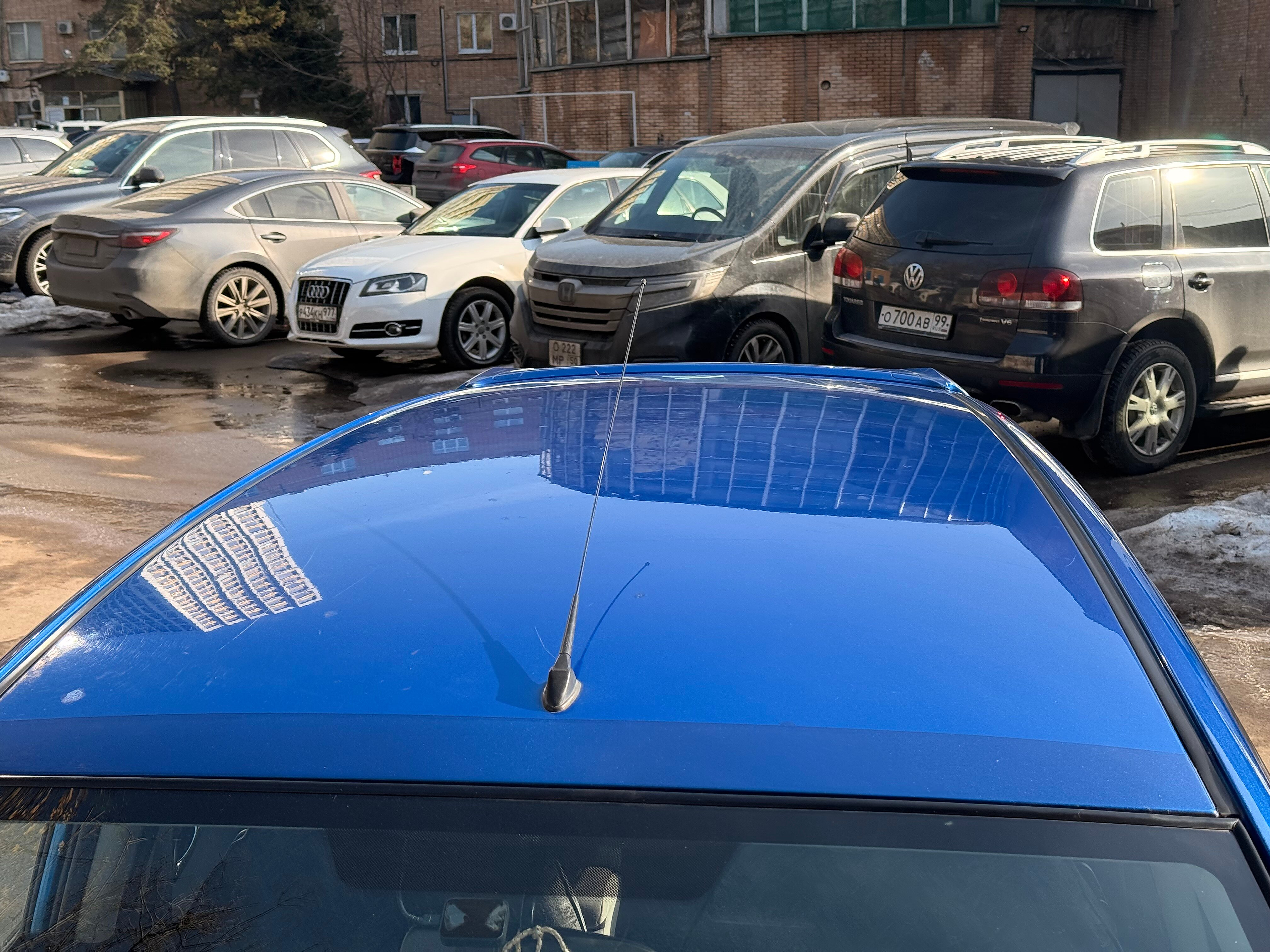 Синяя крыша автомобиля с отражением фасада