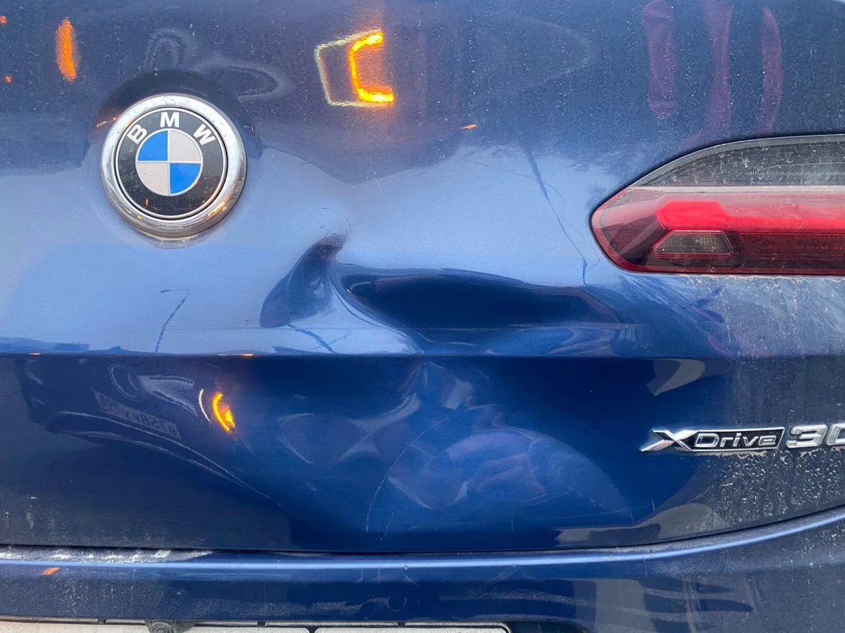 Вмятина на крышке багажника BMW у заднего фонаря
